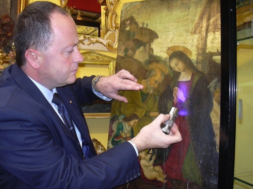 Luca Capecchi osserva un antico dipinto con la luce